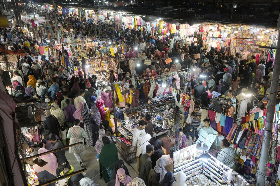 FILE - People visit a market to shop for the upcoming Eid al-Fitr celebrations, in Karachi, Pakistan, Wednesday, April 3, 2024. Eid al-Fitr marks the end of the Islamic holy month of Ramadan. Pakistani authorities have deployed more than 100,000 police and paramilitary forces at mosques and market places across the country ahead of the massive Eid al-Fitr holiday, officials said Tuesday. (AP Photo/Fareed Khan, File)