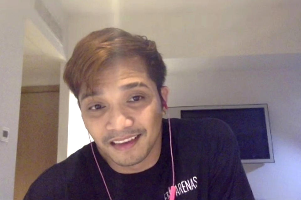 In this image made from video, cruise ship performer Erick Arenas, 34, speaks to the Associated Press via video chat while under quarantine in a hotel in Manila, Philippines, Thursday, May 28, 2020. Tens of thousands of workers have returned by plane and ships as the pandemic, lockdowns and economic downturns decimated jobs worldwide in a major blow to the Philippines, a leading source of global labor. (AP Photo)