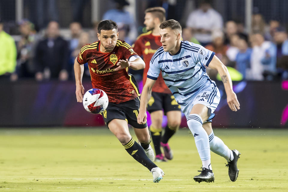 Sporting Kansas City midfielder Remi Walter, right, chases down the ball ahead of Seattle Sounders midfielder Nicolas Lodeiro (10) during the second half of an MLS soccer match on Saturday, March 25, 2023, in Kansas City, Kan. (AP Photo/Nick Tre. Smith)