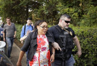 An unidentified member of the foreign security forces helps a civilian to flee a hotel complex in Nairobi, Kenya Tuesday, Jan. 15, 2019. Terrorists attacked an upscale hotel complex in Kenya's capital Tuesday, sending people fleeing in panic as explosions and heavy gunfire reverberated through the neighborhood. (AP Photo/Ben Curtis)