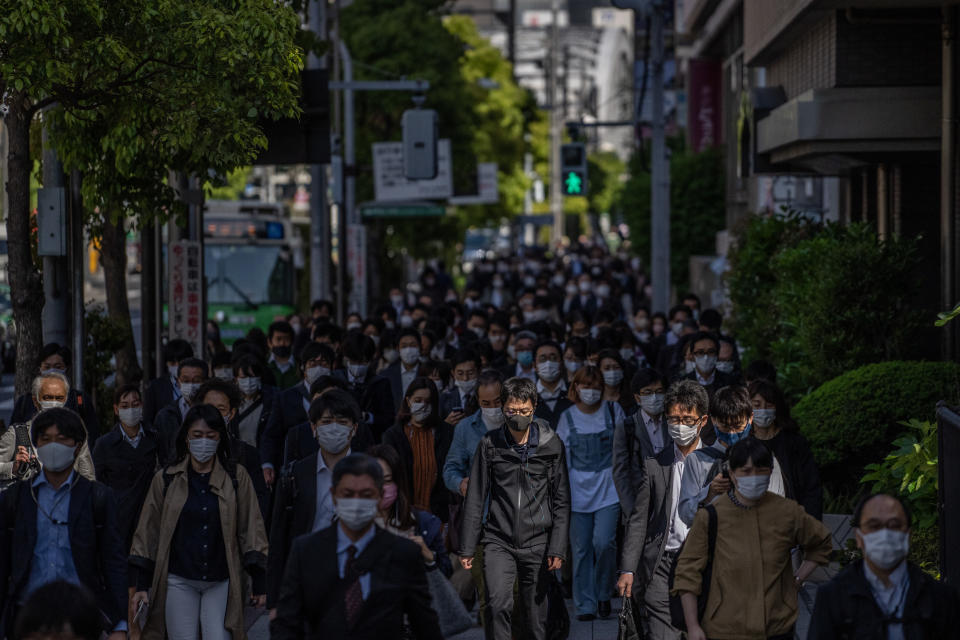 People wearing face masks walk to work on April 23, 2021 in Tokyo, Japan.