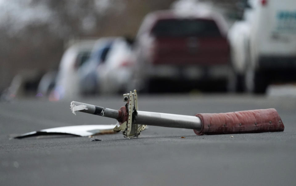 A part from a United Airlines jetliner sits in the middle of Elmwood Street in the street near a home peppered by parts from a plane as it was making an emergency landing at nearby Denver International Airport Saturday, Feb. 20, 2021. (AP Photo/David Zalubowski)
