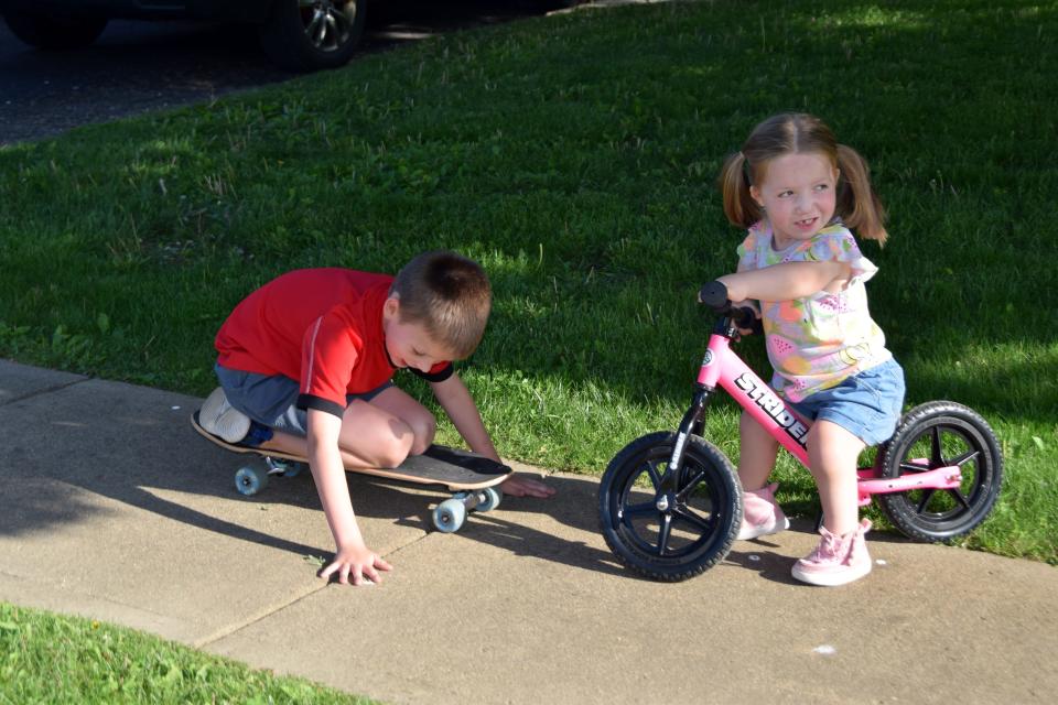 Ellie Messer plays with her older brother AJ Messer outside their home. Both siblings attend Etna Elementary.