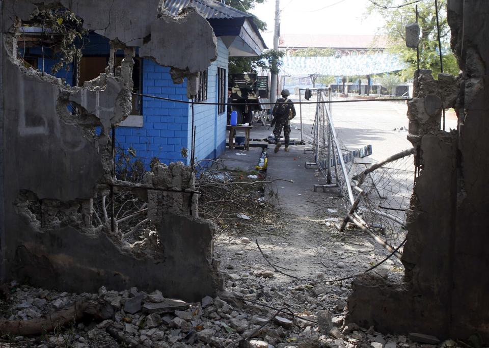 A government soldier stands guard outside a tourist police station in Fort Pilar near a wall destroyed by fighting with Muslim rebels from the Moro National Liberation Front (MNLF) in Zamboanga city in southern Philippines September 15, 2013. (REUTERS/Erik De Castro)