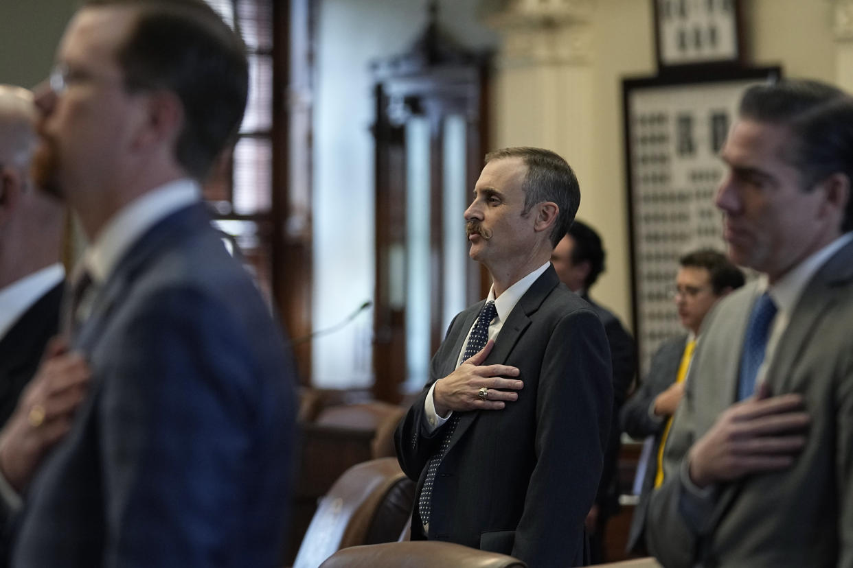 Rep. Andrew Murr, R - Junction, Chair of the House General Investigating Committee, center, joins fellow lawmakers in the pledge before the impeachment proceedings against state Attorney General Ken Paxton in the House Chamber at the Texas Capitol in Austin, Texas, Saturday, May 27, 2023. Texas lawmakers have issued 20 articles of impeachment against Paxton, ranging from bribery to abuse of public trust as state Republicans surged toward a swift and sudden vote that could remove him from office. (AP Photo/Eric Gay)
