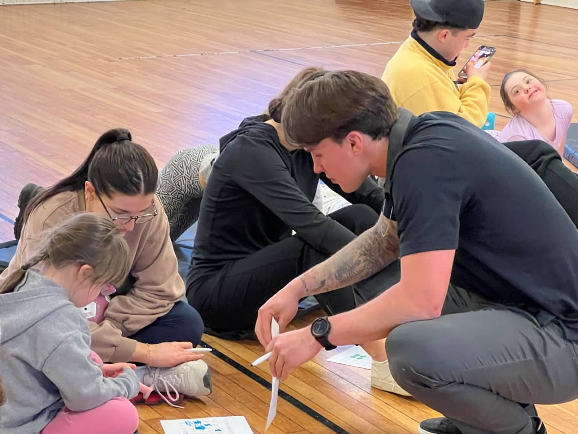 Dalhousie University hockey player Alec Bélanger, right, is the recipient of this year's Atlantic University Sport student-athlete community service award. He started a program that pairs student volunteers with children with Down syndrome and their siblings, offering them a place to play and do activities. (Richard Woodbury/CBC - image credit)