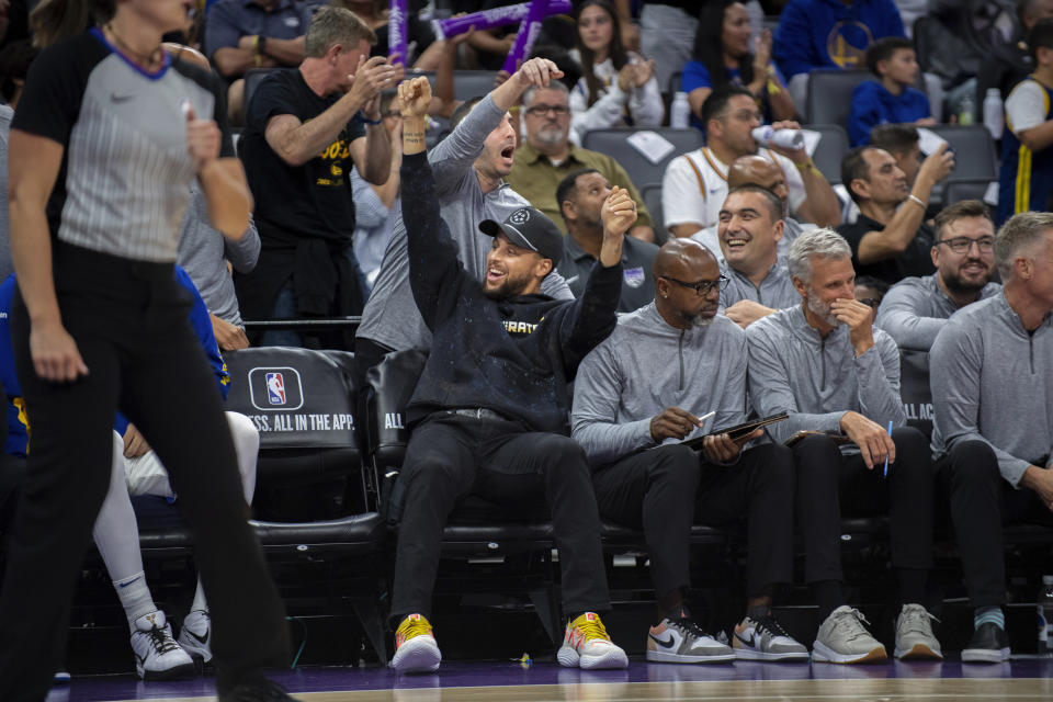 Golden State Warriors guard Stephen Curry cheers after a Warrior basket in the second half in a preseason NBA basketball game against the Sacramento Kings in Sacramento, Calif., Sunday, Oct. 15, 2023. The Warriors won 121-115. (AP Photo/José Luis Villegas)