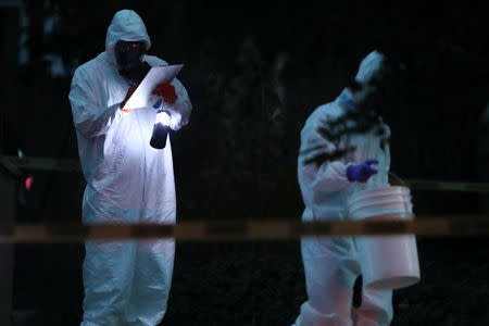 Law enforcement officers takes notes by flashlight and remove items from a house, which FBI says was investigating "potentially hazardous chemicals" in Logan, Utah, U.S., October 3, 2018. REUTERS/George Frey