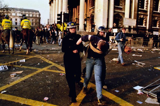 A protester led away by police after a protest against the so-called poll tax (PA)