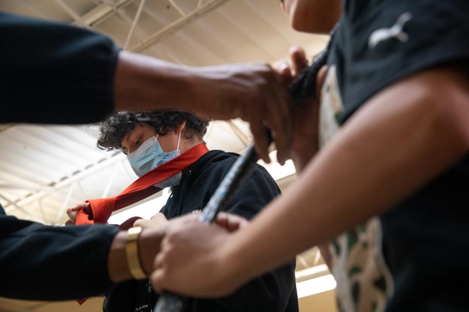 Seventh grade student Michael Arrvizo learns how to tie a tie during Boys Club at John S. Gillett Middle School on Friday, Feb. 9, 2024, in Kingsville, Texas.