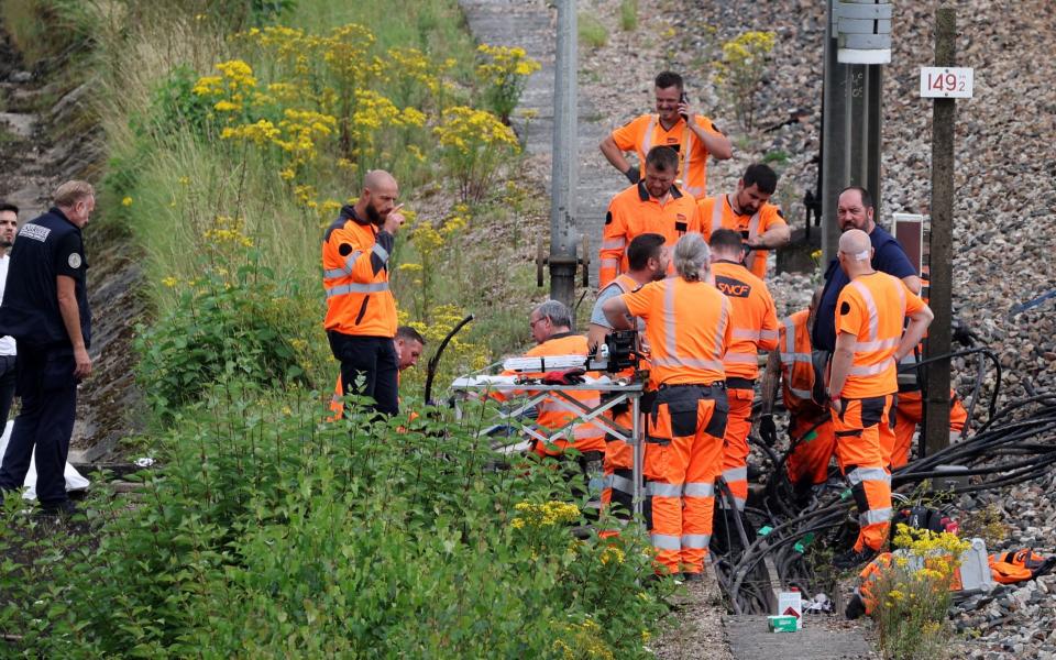 SNCF employees and French police inspect the site of an alleged attack on the high-speed rail network in Croiselles, northern France, on July 26, 2024