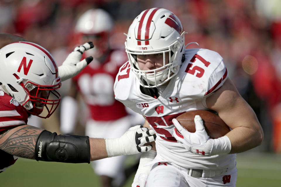 Wisconsin linebacker Jack Sanborn (57) carries the ball against Nebraska running back Dedrick Mills, left, after intercepting a pass by quarterback Adrian Martinez in the first half of an NCAA college football game in Lincoln, Neb., Saturday, Nov. 16, 2019. (AP Photo/Nati Harnik)