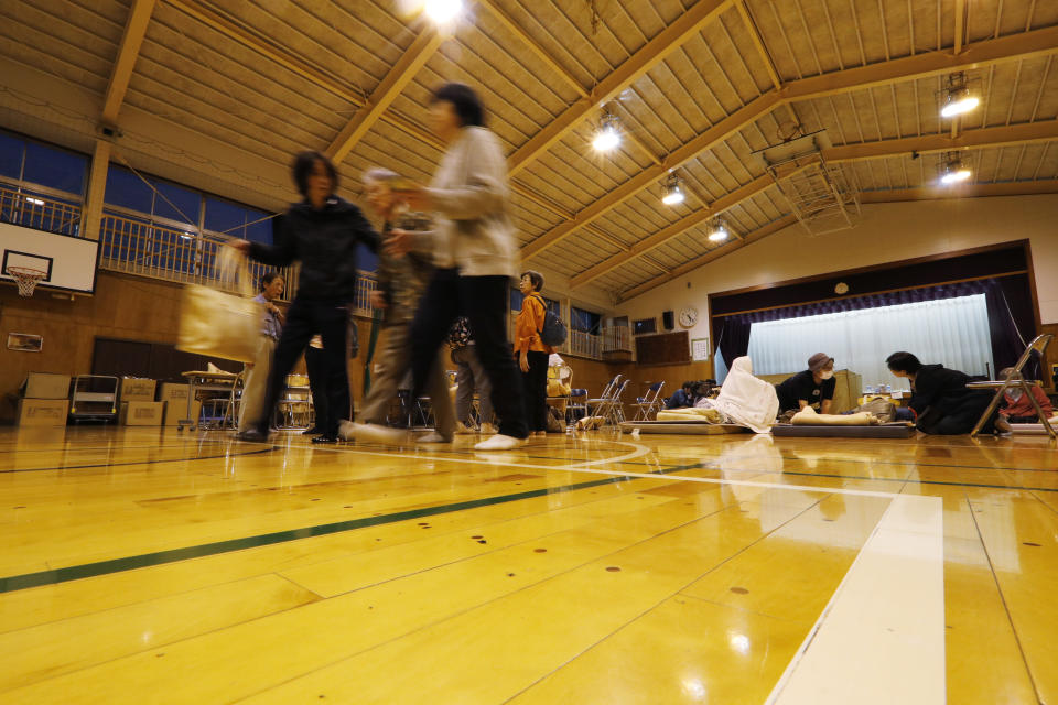 Evacuees from Typhoon Hagibis take shelter at a nearby elementary school gym on Monday, Oct. 14, 2019, in Kawagoe City, Japan. Rescue crews are digging through mudslides and searching near swollen rivers for missing people after Hagibis caused serious damage in central and northern Japan. (AP Photo/Eugene Hoshiko)