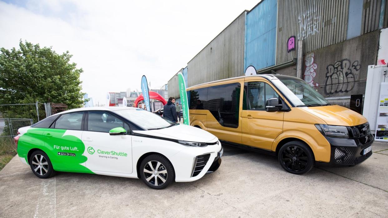 Ein Elektro-Sammeltaxi der VW-Tochter Moia und ein Fahrzeug von Clever Shuttle (l) auf dem New Mobility Day in Hamburg. (Nicht nur) Der Bitkom feilt an neuen Mobilitätskonzepten. Foto: Christian Charisius/Archiv