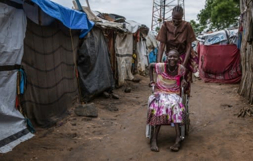 A mother's love: Eleven-year-old Nyamet Steven was born with cerebral palsy -- her mother Nyayom Steven, who has six other children, pushes her wheelchair through the camp