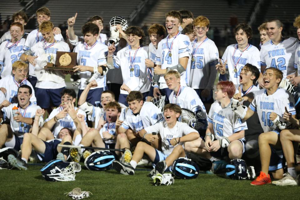 Members of the York High School boys lacrosse team celebrate after beating Messalonskee in the 2023 Class B state championship game at Fitzpatrick Stadium in Portland, Maine. It was the first championship in program history.