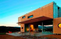 <p>Architecture firm James & Mau partnered modular home company Infiniski on Manifesto House, a shipping container home in Curacaví, Chile. It’s clad in recycled slatted wood pallets, which can be opened to help regulate the temperature inside.</p>