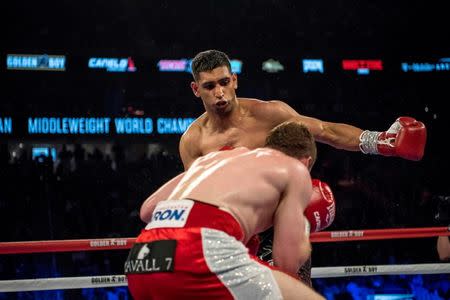 May 7, 2016; Las Vegas, NV, USA; Amir Khan (maroon shorts) punches Canelo Alvarez (red shorts) during their middleweight boxing title fight at T-Mobile Arena. Mandatory Credit: Joshua Dahl-USA TODAY Sports