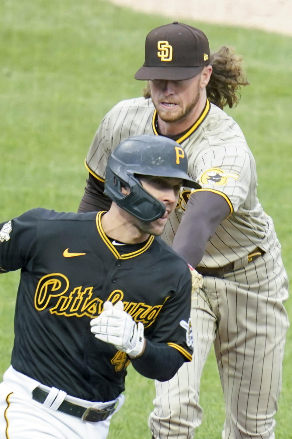 San Diego Padres starting pitcher Chris Paddack, top, tags out Pittsburgh Pirates' Adam Frazier as he heads to first after hitting a ground ball in the second inning of a baseball game, Thursday, April 15, 2021, in Pittsburgh. (AP Photo/Keith Srakocic)