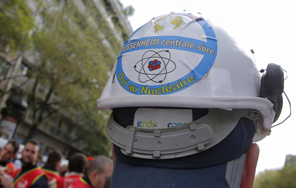 FILE - In this file photo dated Thursday, April 6, 2017, a sticker is photographed on a helmet of an employee of Fessenheim's nuclear power plant opposing the closure, during a protest outside the EDF headquarters in Paris, France. A statement released Wednesday Feb. 19, 2020, that Fessenehim will close one of its reactors on upcoming Saturday, as the first phase of a shut-down at the plant. Sticker on helmet reads, "Fessenheim's power plant secure, yes to the nuclear". (AP/Photo Michel Euler, FILE)