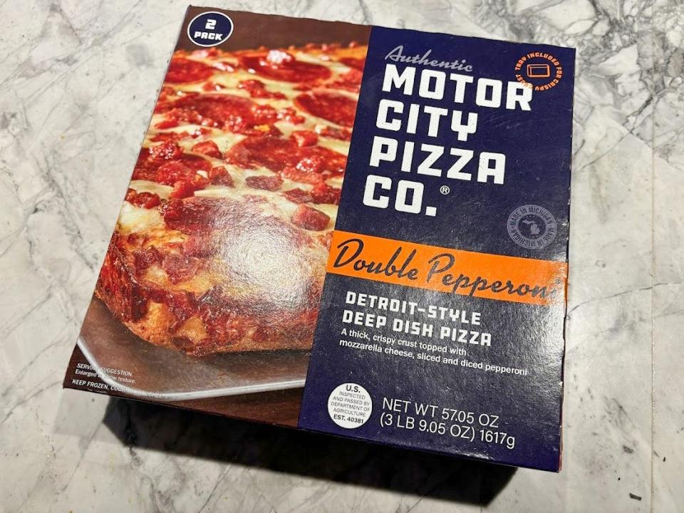 A blue box of pizza with an image of a square-shaped pizza on the front