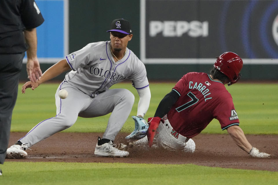 Arizona Diamondbacks' Corbin Carroll steals second base as Colorado Rockies shortstop Ezequiel Tovar waits for the throw during the first inning of a baseball game, Sunday, March 31, 2024, in Phoenix. (AP Photo/Rick Scuteri)