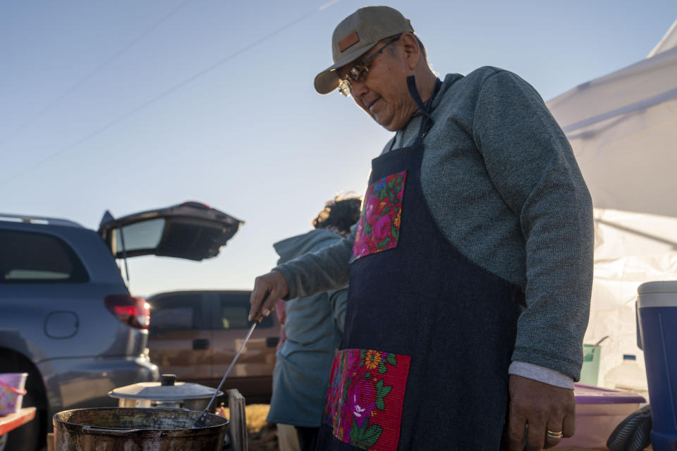 Arnold Goodluck flips dough in oil to produce Navajo fry bread at the Churchrock Chapter House in Church Rock, N.M., on Election Day, Tuesday, Nov. 8, 2022. Navajo voters are deciding Tuesday who they want to be their next president, a position that wields influence nationally because of the tribe's hefty population and the size of it reservation in the U.S. Southwest. (AP Photo/William C. Weaver IV)