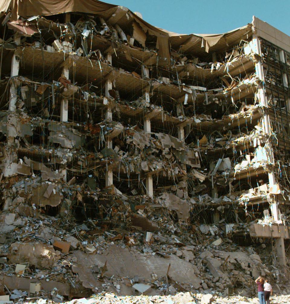 FILE-- In this April 19, 1995, file photo, rescue workers stand in front of the Alfred P. Murrah Federal Building following an explosion in downtown Oklahoma City. One hundred sixty-eight people died as a result of the explosion. The Oklahoma City National Memorial and Museum scaled back its plans for a 25th anniversary remembrance amid the coronavirus outbreak and will instead offer a recorded, one-hour television program that includes the reading of the names of the 168 people killed in the bombing followed by 168 seconds of silence. (AP Photo/David Longstreath, File)