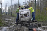 Electrical workers ride through marsh in a marsh buggy to restore power lines in the aftermath of Hurricane Ida in Houma, La., Friday, Sept. 17, 2021. The Louisiana terrain presents special challenges like just getting out to some of the areas where power poles and lines need to be fixed. In some areas lines thread through thick swamps that can only be accessed by air boat or specialized equipment like a marsh buggy. Linemen don waders to climb into chest-high muddy waters also home to alligators and water moccasins. (AP Photo/Gerald Herbert)