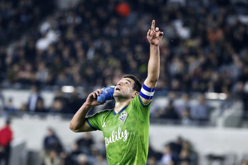 Seattle Sounders midfielder Nicolas Lodeiro celebrates his goal while holding his shoe during the first half of the team's MLS soccer Western Conference final against Los Angeles FC, Tuesday, Oct. 29, 2019, in Los Angeles. (AP Photo/Ringo H.W. Chiu) ** Usable by HOY, ELSENT and SD Only **