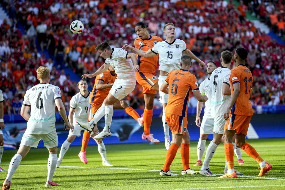 Virgil van Dijk de Holanda, en el centro, el austríaco Philipp Lienhart, a la derecha, y Maximilian Wober saltan por el balón durante un partido del Grupo D entre Holanda y Austria en la Eurocopa 2024 en Berlín, Alemania, el martes 25 de junio de 2024. (AP Foto/Ebrahim Noroozi)