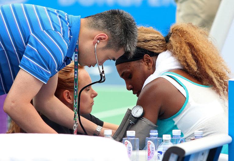 Medical personnel treat Serena Williams of the US (R) during her match against France's Alize Cornet at the Wuhan Open in China on September 23, 2014