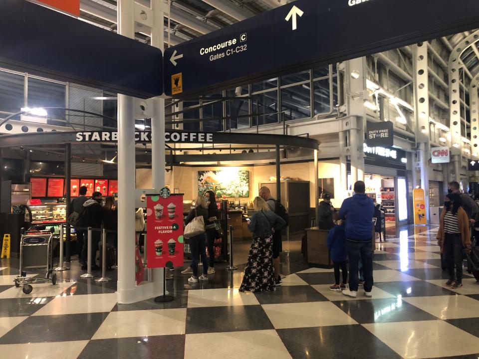 Travelers wait to place an order at a Starbucks at O'Hare International Airport in Chicago.