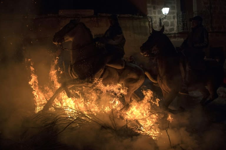 Horsemen jump over a bonfire as part of the age-old Las Luminarias festival in the Spanish village of San Bartolome de Pinares