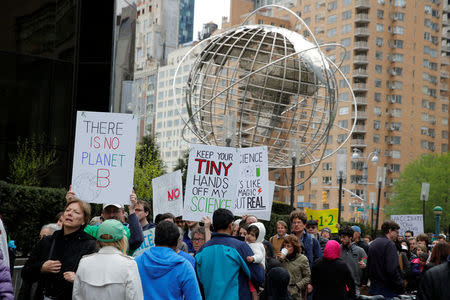 People walk past Trump International Hotel and Tower during the Earth Day 'March For Science NYC' demonstration to coincide with similar marches globally in Manhattan, New York, U.S., April 22, 2017. REUTERS/Andrew Kelly