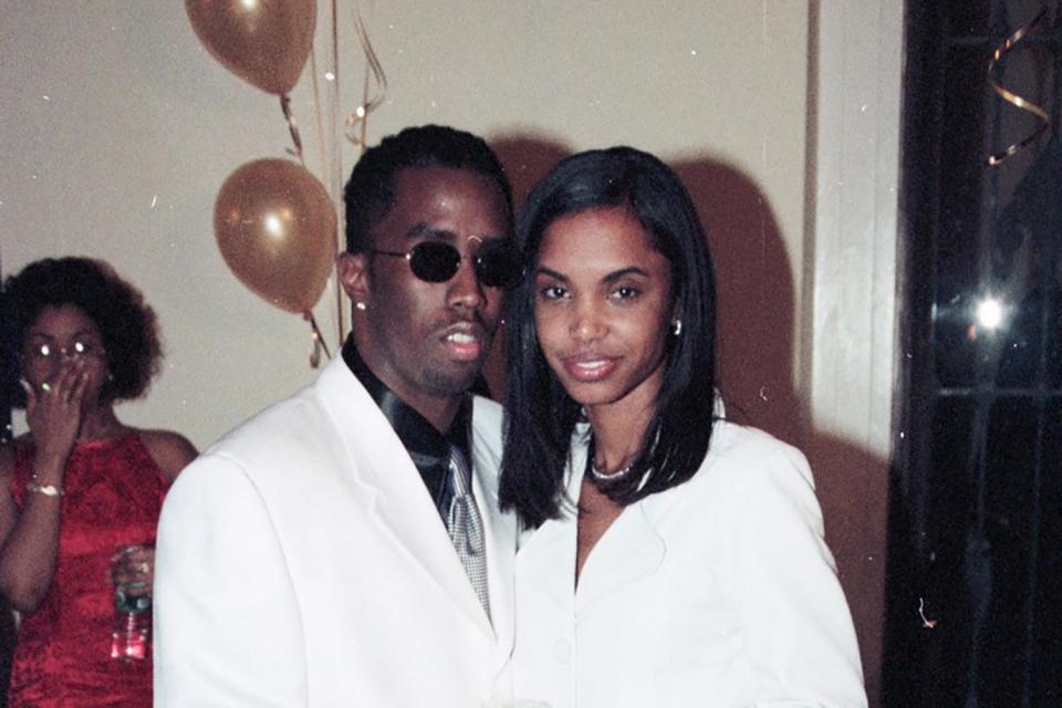 Portrait of American couple, rapper Sean Combs and Kimberly Porter (1970 - 2018), as they pose with a bottle of Louis Roederer Cristal Champagne during a New Year's Eve celebration, New York, New York, December 31, 1994. (Photo by Nitro/Getty Images)