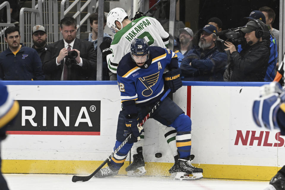 St. Louis Blues defenseman Justin Faulk (72) fights for the puck against Dallas Stars' Jani Hakanpaa (2) during the third period of an NHL hockey game Wednesday, Dec. 27, 2023, in St. Louis. (AP Photo/Michael Thomas)