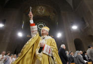 CORRECTS THE PUBLISHED DATE OF THE GRAND JURY REPORT TO AUG. 14, NOT 15 - FILE - In this Sunday, April 24, 2011 file photo, Cardinal Donald Wuerl, Archbishop of Washington, sprinkles Holy Water during Easter Mass at the Basilica of the National Shrine of the Immaculate Conception Roman Catholic Church in Washington. On Tuesday, Aug. 14, 2018, a Pennsylvania grand jury accused Cardinal Wuerl of helping to protect abusive priests when he was Pittsburgh's bishop. (AP Photo/Alex Brandon)