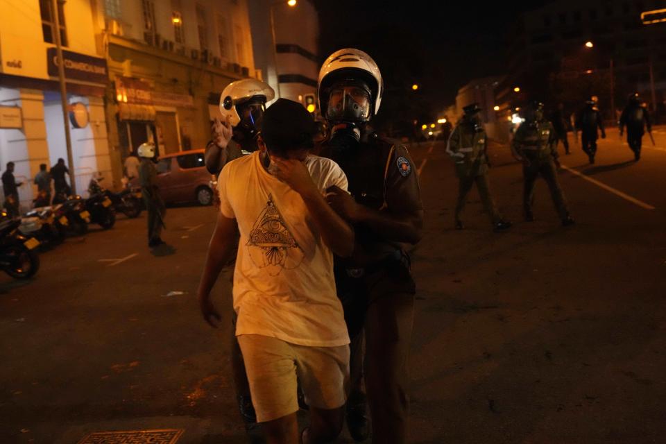 Police officers detain an anti government protester near the president's official residence in Colombo, Sri Lanka, Saturday, May 28, 2022. Police fired tear gas and water canon on protesters who marched toward the president Gotabaya Rajapaksa's barricaded residence demanding his resignation. (AP Photo/Eranga Jayawardena)