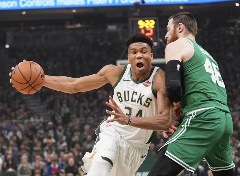 File-This May 8, 2019, file photo shows Milwaukee Bucks' Giannis Antetokounmpo driving past Boston Celtics' Aron Baynes during the first half of Game 5 of a second round NBA basketball playoff series in Milwaukee. Leading the Bucks’ resurgence is MVP candidate Antetokounmpo, a fan favorite and a source of pride for Milwaukee’s Greek community. Antetokounmpo was born in Athens, Greece.“It’s important for the Greek community to be able to gather together as a unit and celebrate him. And he in turn celebrates us,” said Tim Stasinoulias, 61, a Bucks fan since the team came to Milwaukee in 1968.(AP Photo/Morry Gash, File)