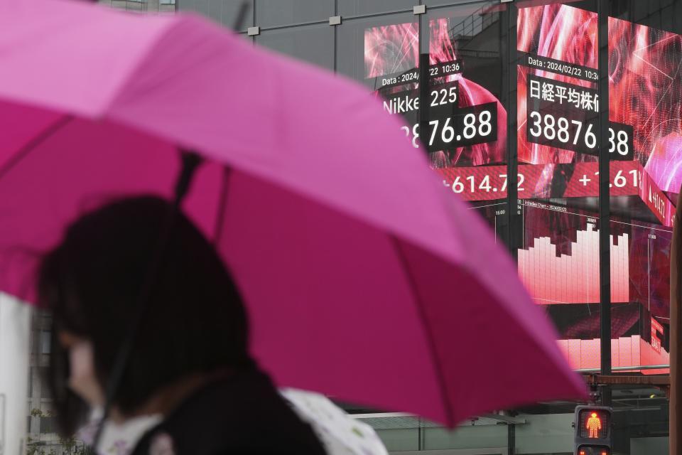 A person stands in front of an electronic stock board showing Japan's Nikkei 225 index at a securities firm Thursday, Feb. 22, 2024, in Tokyo. Asian markets retreated Friday, March 15, with Hong Kong’s benchmark falling nearly 2%, after a mixed batch of data on the U.S. economy dashed hopes that easier interest rates are coming soon.(AP Photo/Eugene Hoshiko, File)