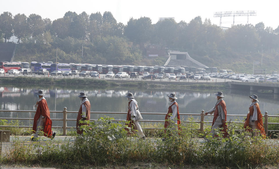 Buddhist monks walk along a stream in Seoul, South Korea, Tuesday, Oct. 27, 2020. About 100 monks and followers marched the 500 kilometer (310 mile) pilgrimage to pray for the country to overcome the coronavirus. (AP Photo/Lee Jin-man)