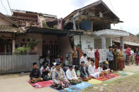 People perform Friday prayer near houses damaged in Monday's earthquake, in Cianjur, West Java, Indonesia, Friday, Nov. 25, 2022. The magnitude 5.6 quake killed hundreds of people, many of them children, and injured thousands. (AP Photo/Rangga Firmansyah)