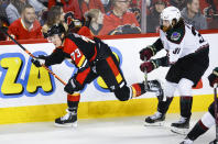 Arizona Coyotes forward Liam O'Brien, right, checks Calgary Flames forward Tyler Toffoli during the second period of an NHL hockey game in Calgary, Alberta, Monday, Dec. 5, 2022. (Jeff McIntosh/The Canadian Press via AP)