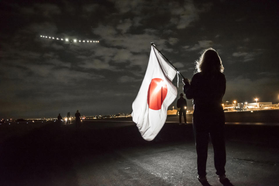 <p>Yasemine Borschberg waves a Japanese flag as Solar Impulse 2 takes off from Nagoya Komaki airport, with her husband Andre Borschberg as the pilot. Tis eight leg of the journey took the plane to Hawaii. (Jean Revillard/SI2/Global Newsroom via Getty Images)</p>