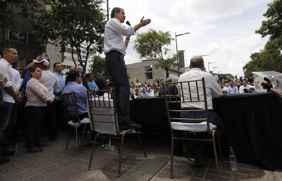 Venezuelan opposition political leader Juan Guaido speaks to supporters and opposition lawmakers after their march was blocked by police in Caracas, Venezuela, Tuesday, March 10, 2020. Guaido's march aimed at retaking the National Assembly legislative building, which opposition lawmakers have been blocked from entering. (AP Photo/Ariana Cubillos)