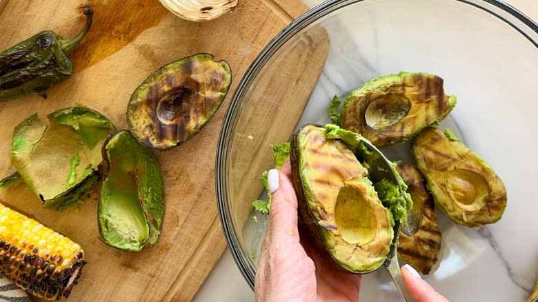 hand scooping out avocado