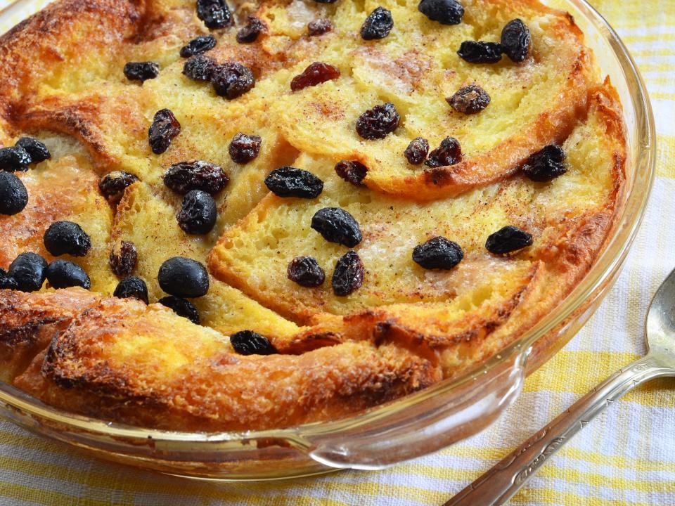 bread and butter pudding with raisins in a dish with a spoon