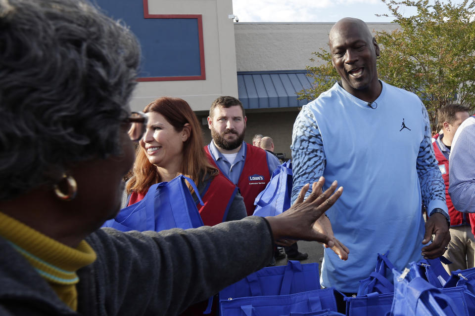 Charlotte Hornets owner Michael Jordan greets people and hands out food for Thanksgiving to members of the community in Wilmington, N.C., Tuesday, Nov. 20, 2018. (AP Photo/Gerry Broome)