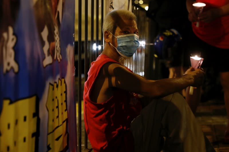 Man attends a candlelight vigil ahead of the 31st anniversary of the crackdown of pro-democracy protests at Beijing's Tiananmen Square in 1989, in Hong Kong